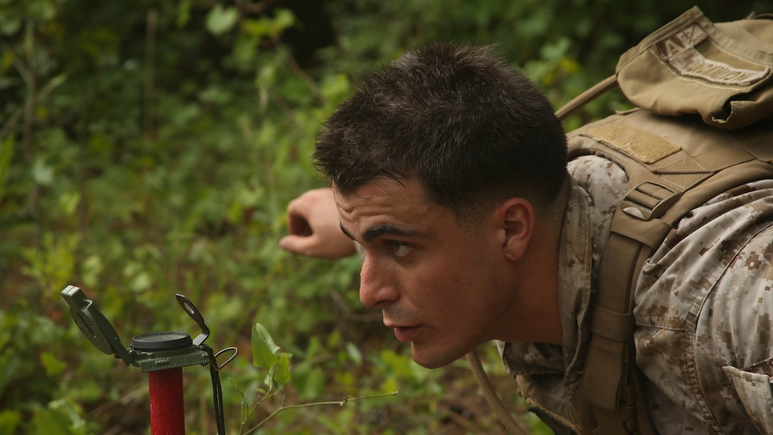 A Marine with 1st Battalion, 8th Marine Regiment, 2nd Marine Division, looks through the site of a compass as his team prepares to set up an 81mm Mortar aboard Camp Lejeune, N.C. July 30, 2014. Marines in the unit took part in a training event in which they were taught the practical application of the “hip shoot” as well as refining their basic skill sets. 