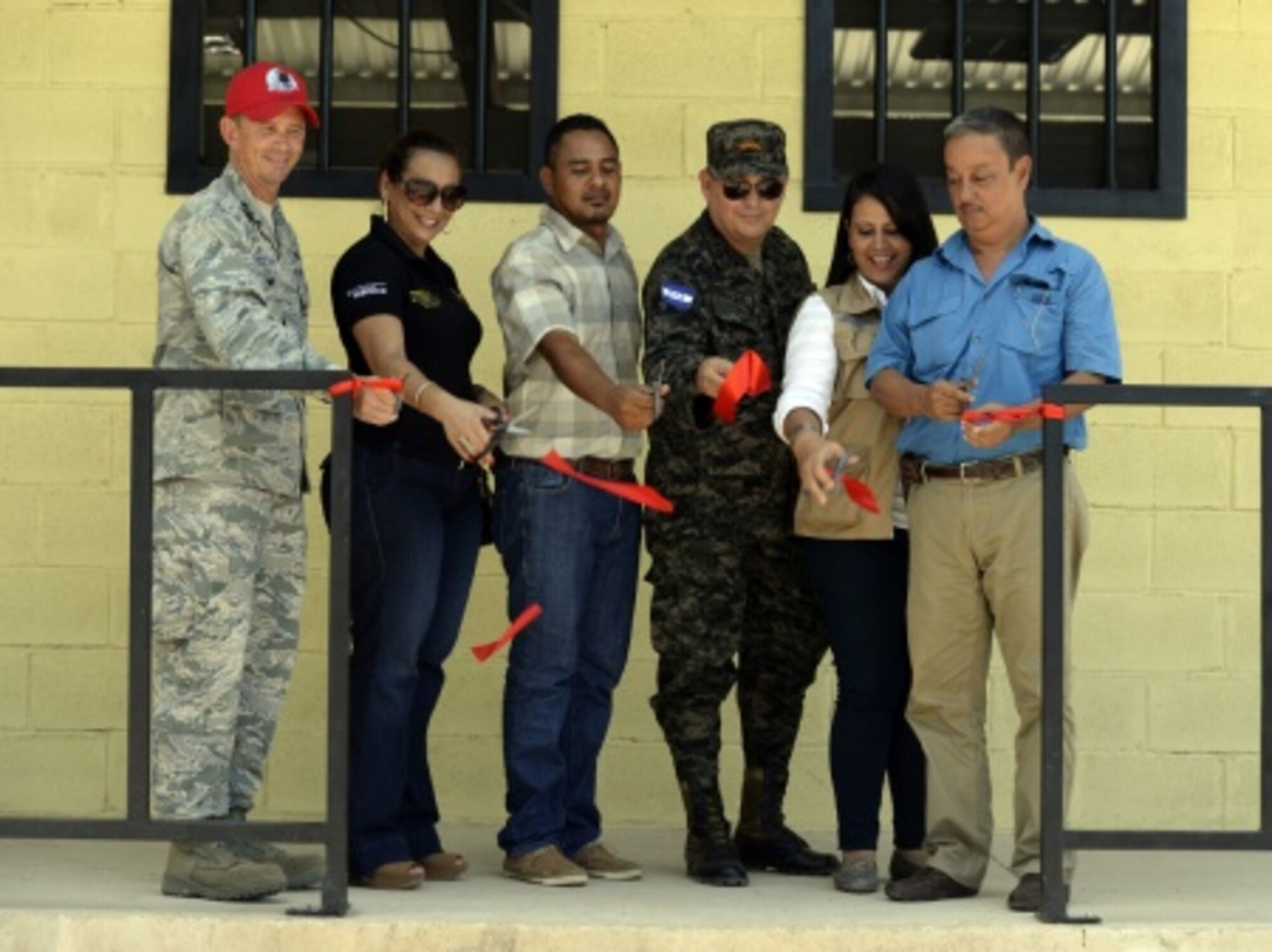 (From left to right) U.S. Air Force Lt. Col. Ryan Elliott, 823rd RED HORSE Squadron deputy commander and New Horizons Honduras exercise commander, out of Hurlburt Field, Fla., and a native of Grove City, Pa.; Director Doris Maradiaga, Colón Department of Education district director; Principal Abraham Ruiz, Gabriela Mistral school; Honduran Army Col. Rafael Deras, 15th Battalion commander: Ghisell Padilla, Colón Department governor; and Trujillo Mayor José Antonio Lainez cut the ribbon of the new two-classroom schoolhouse at the Gabriela Mistral school in Ocotes Alto, July 28, 2015, as part of the ribbon-cutting ceremony. The event marked the official opening of the building which was one of the key projects as part of the New Horizons Honduras 2015 training exercise taking place in around Trujillo, Honduras. New Horizons was launched in the 1980s and is an annual joint humanitarian assistance exercise that U.S. Southern Command conducts with a partner nation in Central America, South America or the Caribbean. The exercise improves joint training readiness of U.S. and partner nation civil engineers, medical professionals and support personnel through humanitarian assistance activities. (U.S. Air Force photo by Capt. David J. Murphy/Released)
