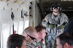 Army Sgt. Frank Kiler, a C-23B Sherpa flight engineer with Detachment 1, Company D, 126th Aviation, scans the cargo area to ensure the safety of all of those onboard as the aircraft climbs towards 12,500 ft. July 26, 2011. The Sherpa was working with the U.S. Navy as they performed high-altitude, low-opening para-jumps.