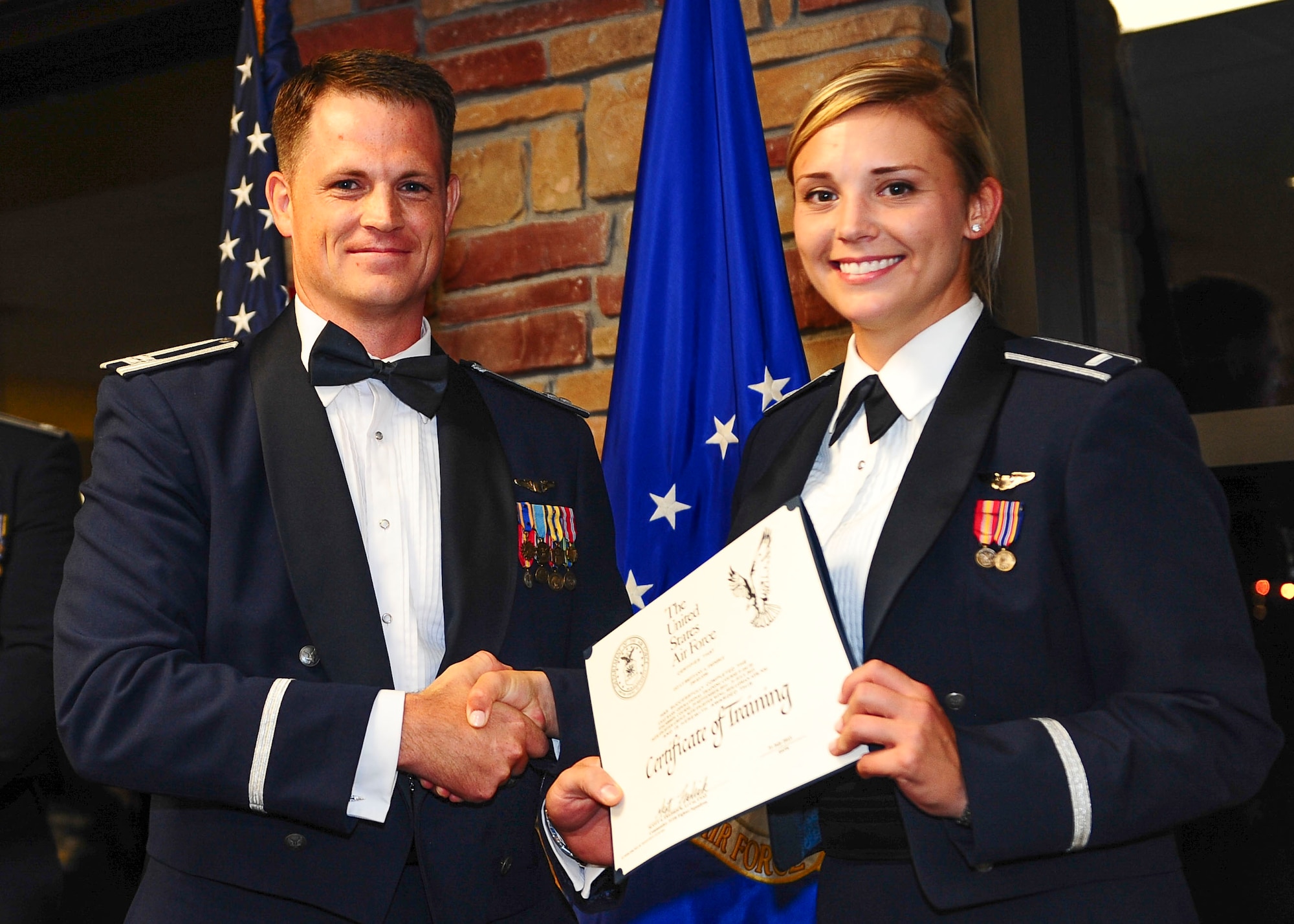 First Lt. Brittany Trimble (right) poses for a picture after accepting her diploma July 31 at Holloman Air Force Base, N.M. The class, 14-FBH, is the first class of F-16 Fighting Falcon pilots to graduate from Holloman. Trimble was one of 14 graduates. The 311th FS is a geographically separated unit belonging to Luke Air Force Base, Arizona. (U.S. Air Force photo by Amn Randahl J. Jenson)