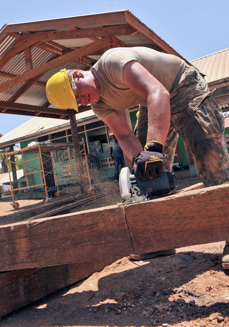 Cadet Justin Kolbeck cuts through a piece of wood to be used in a sun shelter at the Pater van der Pluym School in Brownsweg, Suriname, Aug. 8, 2011. Kolbeck, a cadet with the 155th Engineering Company in Rapid City, S.D., is helping remodel the school during the New Horizons 2011 exercise.