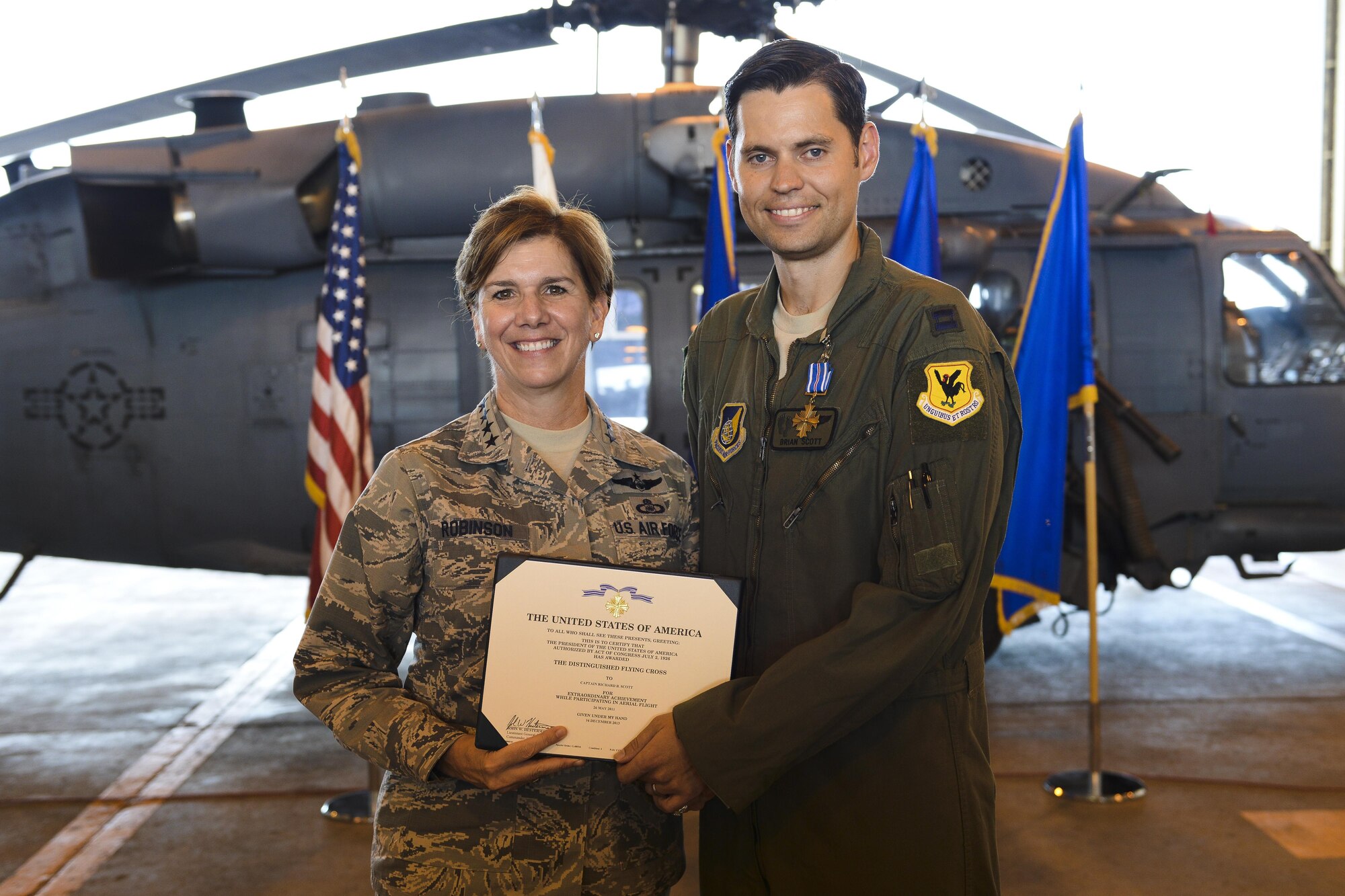 U.S. Air Force Gen. Lori Robinson, Pacific Air Forces commander, presents the Distinguished Flying Cross to U.S. Air Force Capt. Richard Scott, 33rd Rescue Squadron evaluator pilot, on Kadena Air Base, Japan, Aug. 3, 2015. Scott was awarded for his contribution in a harrowing rescue mission in Afghanistan on May 26, 2011, when he provided a precision hoist to a squad of U.S. Army Pathfinders who were ambushed by multiple improvised explosive devices. (U.S. Air Force photo by Airman 1st Class John Linzmeier/Released)
