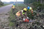 The Virginia National Guard's Army Spc. Brent Hart, Army Staff Sgt. Ronald
Cruz and Army Sgt. 1st Class Jerry Bristow work to clear debris after
Hurricane Isabel in 2003.