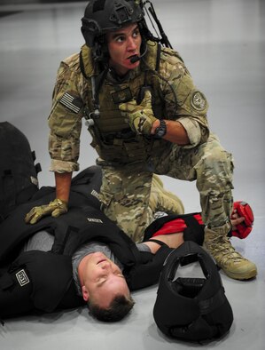 Senior Airman Daniel Santana, 1st Special Operations Security Forces Squadron deployed aircraft ground response element team member, kneels beside a captured member of opposition forces during a task force exercise on Hurlburt Field, Fla., July 24, 2015. Exercise scenarios included downed aircraft site security and armed escort. Through the scenarios, DAGRE was able to accomplish multiple training objectives including close quarters combat, small unit tactics, flight deck denial, fly away security, close air support, casualty evacuation and more. (U.S. Air Force photo by Senior Airman Meagan Schutter)