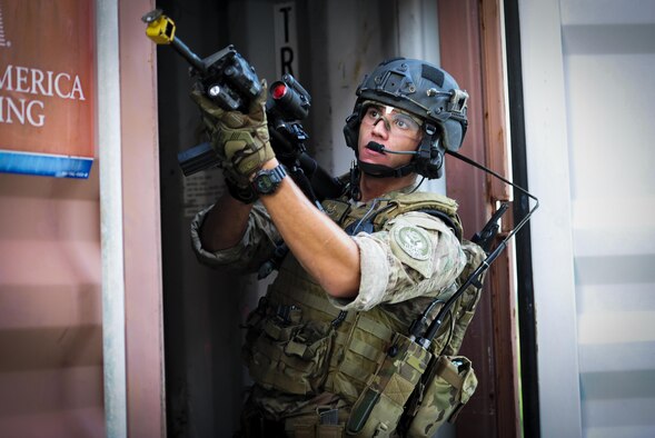 Senior Airman Daniel Santana, 1st Special Operations Security Forces Squadron deployed aircraft ground response element team member, secures a doorway during a task force exercise on Eglin Range Complex, Fla., July 27, 2015. Exercise scenarios included downed aircraft site security and armed escort. Through the scenarios, DAGRE was able to accomplish multiple training objectives including close quarters combat, small unit tactics, flight deck denial, fly away security, close air support, casualty evacuation and more. (U.S. Air Force photo by Senior Airman Meagan Schutter)