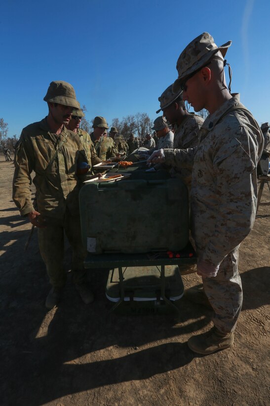 U.S. Marines with Marine Rotational Force – Darwin serve burgers and hotdogs to Australian soldiers to celebrate the Fourth of July on July 5 to bring an end to Exercise Koolendong at Bradshaw Field Training Area, Northern Territory, Australia. Koolendong is a bilateral combined arms training exercise that combined light infantry, indirect fire weapons systems and air assets during training events. The rotational deployment of U.S. Marines in Darwin enables them to more effectively train, exercise, and operate with partners, enhances regional security and builds capacity to respond more rapidly to natural disasters and crises throughout that region.