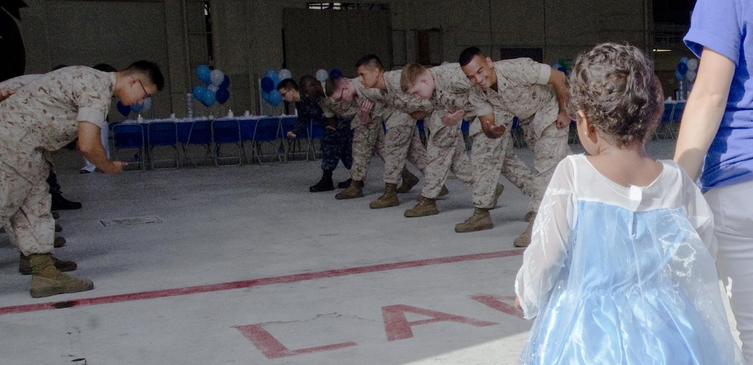 The Marines and Sailors of Marine Aviation Logistics Squadron 24 act as modified “sideboys” to welcome “Princess” Nahla Nepaulsingh, 4, escorted by Jenna Wawrzyniec (right), a wish granter with Make-A-Wish Foundation of Hawaii, into Hangar 375, Aug. 1, 2015. The Make-A-Wish Foundation of Hawaii and MALS-24 hosted a party to announce that Nahla’s wish was granted, and she and her family will be going to Walt Disney World in Orlando, Fla., in September. The Marines, Sailors and families played in makeshift snow and enjoyed refreshments during the celebration. Nahla was diagnosed with acute lymphoblastic leukemia in September 2014. The Nepaulsingh family also raised money for the American Cancer Society while participating in the Relay for Life of Windward Oahu event at Kailua High School, July 11. The mission of Marine Corps Base Hawaii is to provide facilities, programs and services in direct support of units, individuals and families in order to enhance and sustain combat readiness for all operating forces and tenant organizations aboard the installation. (U.S. Marine Corps photo by Kristen Wong/Released)