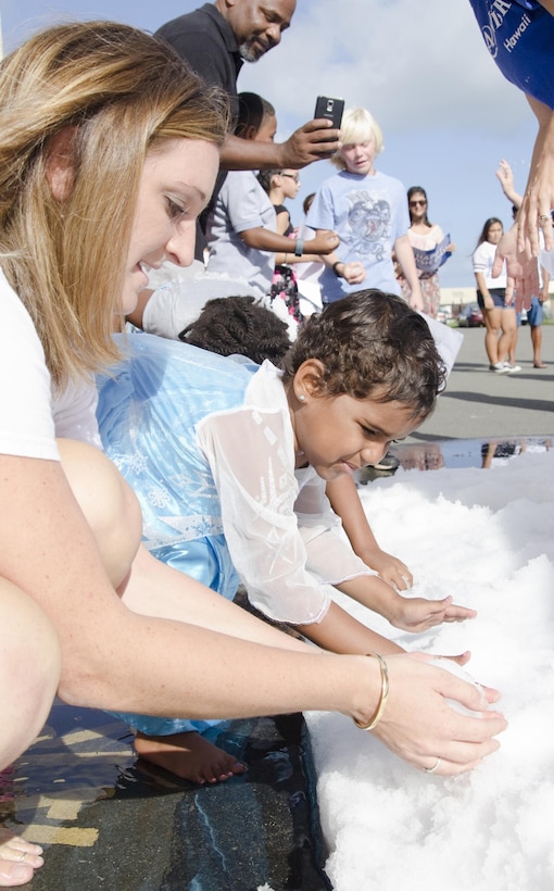 Jessica Agnew (left), a wish granter at Make-A-Wish Foundation of Hawaii, teaches Nahla Nepaulsingh, 4, how to build a snowman outside of Hangar 375, Aug. 1, 2015. The Make-A-Wish Foundation of Hawaii and MALS-24 hosted a party to announce that Nahla’s wish was granted, and she and her family will be going to Walt Disney World in Orlando, Fla., in September. The Marines, Sailors and families played in makeshift snow and enjoyed refreshments during the celebration. Nahla was diagnosed with acute lymphoblastic leukemia in September 2014. The Nepaulsingh family also raised money for the American Cancer Society while participating in the Relay for Life of Windward Oahu event at Kailua High School, July 11. The mission of Marine Corps Base Hawaii is to provide facilities, programs and services in direct support of units, individuals and families in order to enhance and sustain combat readiness for all operating forces and tenant organizations aboard the installation. (U.S. Marine Corps photo by Kristen Wong/Released)