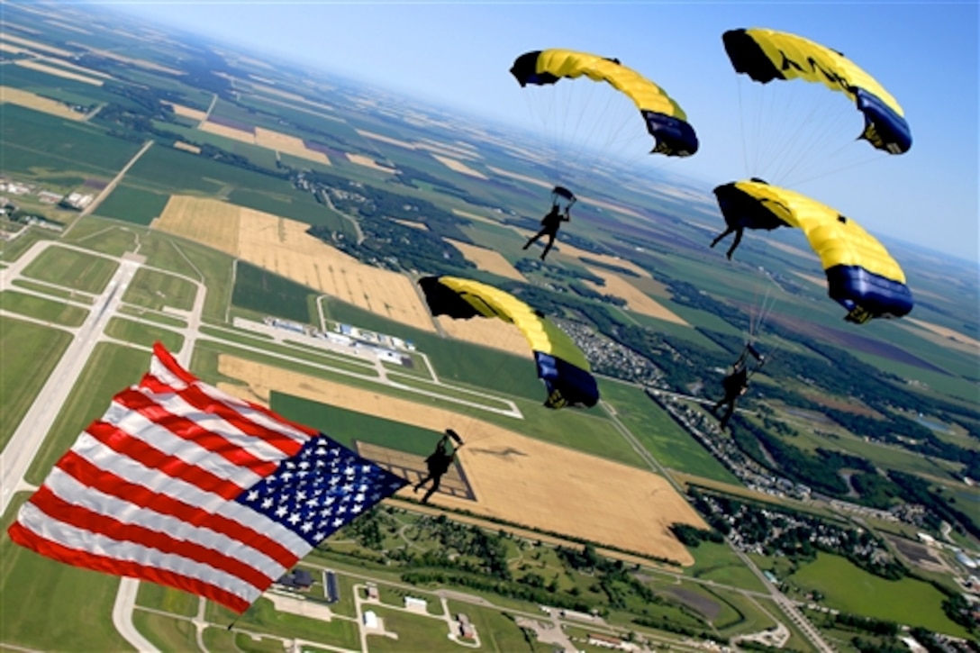 Members of the U.S. Navy Parachute Team, the Leap Frogs, perform a diamond formation while flying the American flag during a demonstration at the Fargo Air Show in Fargo, N.D., July 26, 2015. Based in San Diego, the Leap Frogs perform aerial parachute demonstrations around the nation to support naval special warfare and Navy recruiting.