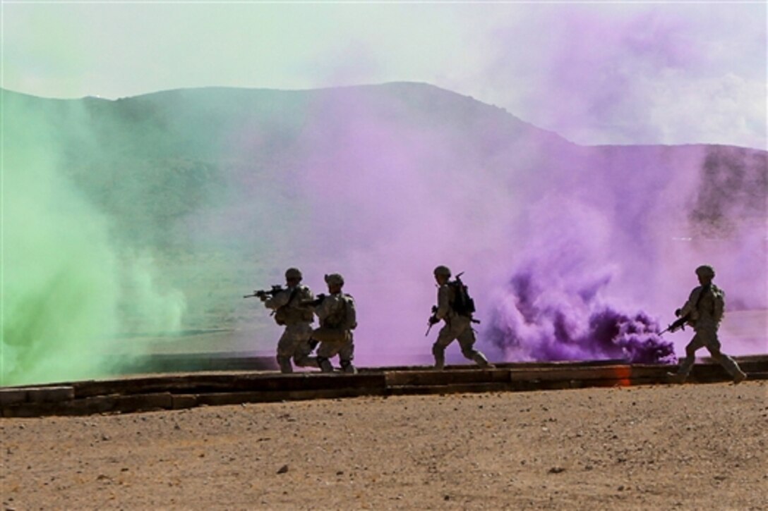 Army paratroopers assault an enemy-held urban environment at a live-fire range at the National Training Center on Fort Irwin, Calif., Aug. 1, 2015. The paratroopers completed several blank and live-fire iterations during the day and at night, sharpening their proficiency at battle drills in the austere environment of the Mojave Desert.