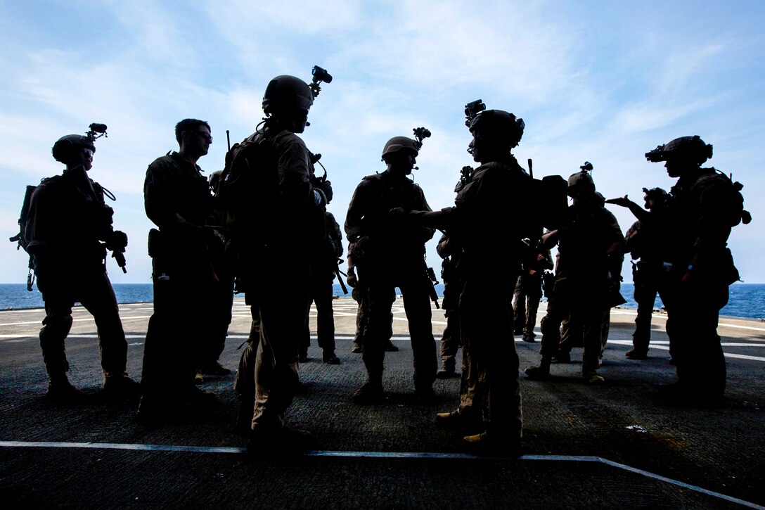 U.S. Marines and Navy SEALs debrief during a joint visit, board, search and seizure exercise as part of composite training in the Atlantic Ocean, July 20, 2015. The Marines, assigned to Maritime Raid Force, 26th Marine Expeditionary Unit, and sailors assigned to the Kearsarge Amphibious Ready Group are participating in the exercise to prepare for deployment to the 5th and 6th Fleet areas of responsibility this fall. 