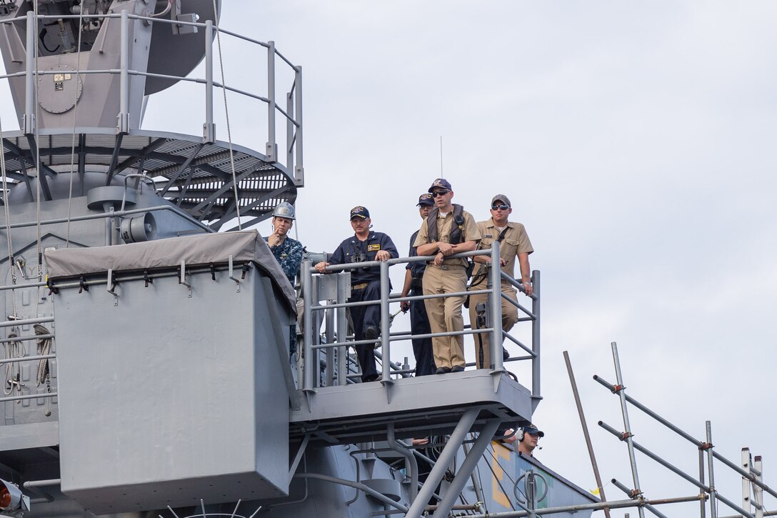 U.S. Navy Capt. Adam M. Aycock, second from left, commanding officer of the guided-missile cruiser USS Shiloh, monitors his ship's alignment as Shiloh is brought into a dry-dock for scheduled maintenance availability in Yokosuka, Japan, July 29, 2015. 