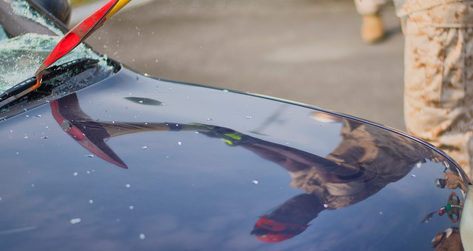 A Marine Corps Air Station Iwakuni firefighter removes the windshield of a car during a vehicle extrication demonstration Aug. 4, 2015, at Yokota Air Base, Japan. Depending of the severity of the crash, firefighters use tools to remove victims from the site and ensure their safety.  (U.S. Air Force photo by Airman 1st Class Delano Scott/Released)