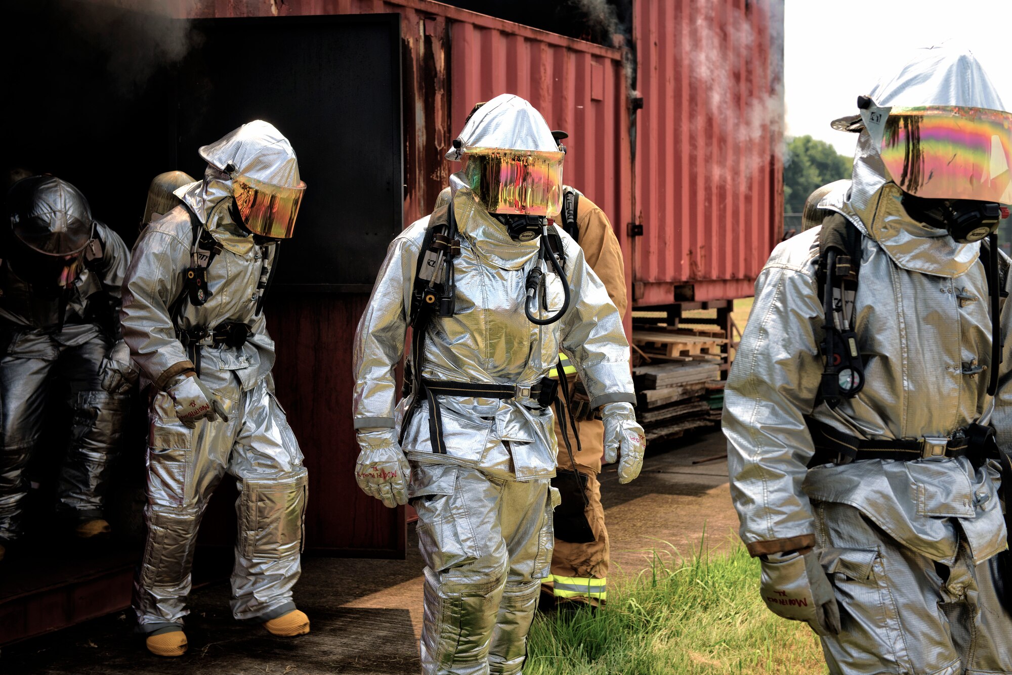 Firefighters from Marine Corps Air Station Iwakuni exit a flashover trainer Aug. 4, 2015, at Yokota Air Base, Japan. Flashover, a near-simultaneous ignition of many objects in a confined room, creates a dangerous situation where both heat and smoke continue to increase until combustion. The training helped to prepare Airmen and Marine firefighters for this potential threat. (U.S. Air Force photo by Airman 1st Class Delano Scott/Released)