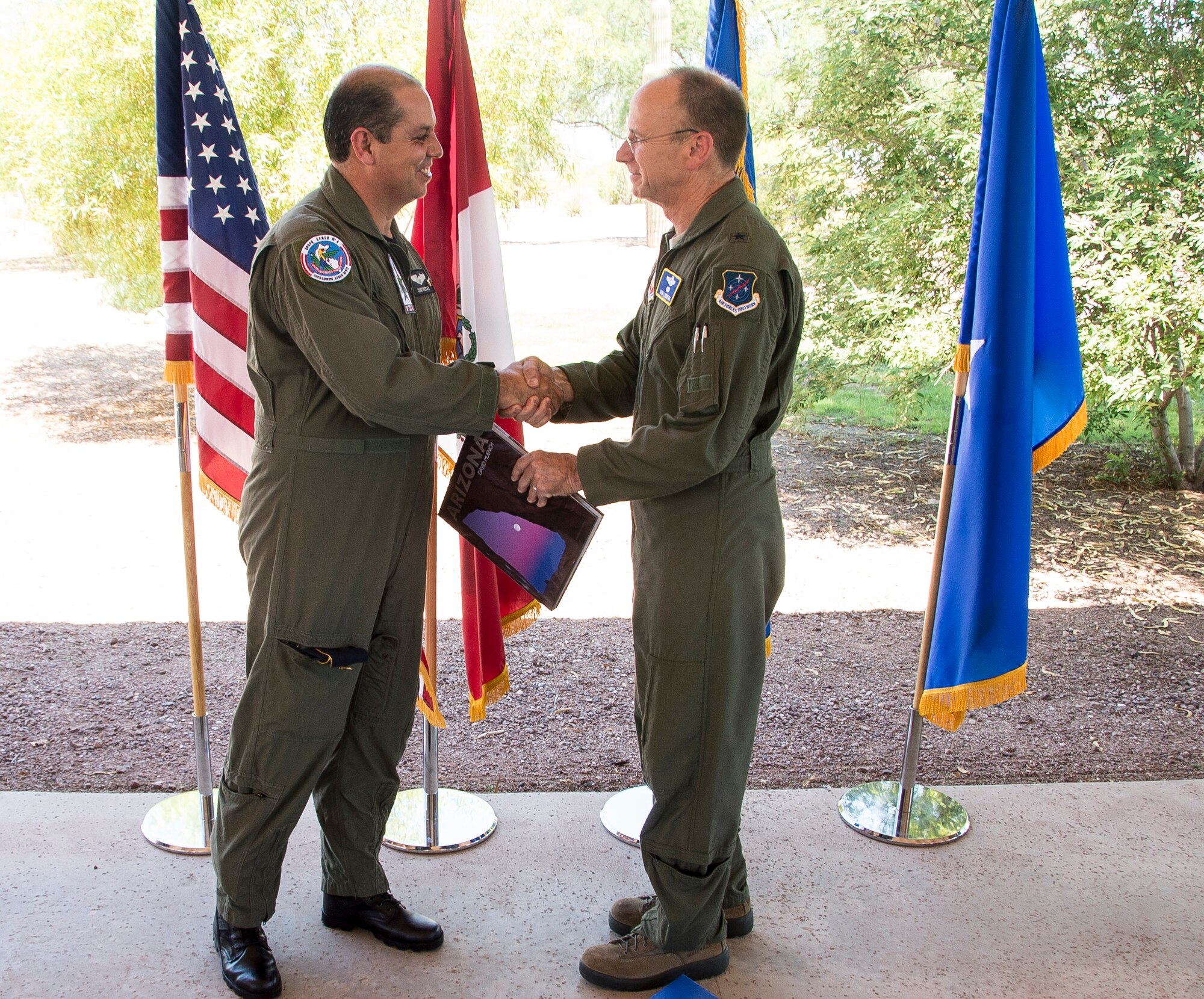 Peruvian Maj. Gen. Mario Contreras, director of the Central Hospital of the Peruvian Air Force, and U.S. Air Force Brig. Gen. Donald Lindberg, 12th AF (AFSOUTH) mobilization assistant to the commander, exchange gifts during a bar-b-que to celebrate the end of PANAMAX 2015, on Davis-Monthan AFB, Ariz., Aug. 4, 2015. The PANAMAX exercise is designed to provide interoperability training for participating multinational staffs, as well as help build-up participating nation’s capability to plan and execute complex multinational operations. (U.S. Air Force photo by Staff Sgt. Adam Grant/Released)