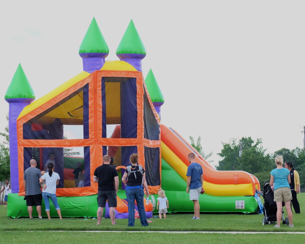 Joint Base Andrews parents watch their children play in an inflatable castle during the National Night Out August 4, 2015, at the Liberty Park Housing Center on JBA, Md. This even offers communities the opportunity to gather together to promote awareness, safety and neighborhood unity. (U.S. Air Force photo by Senior Airman Preston Webb/Released)