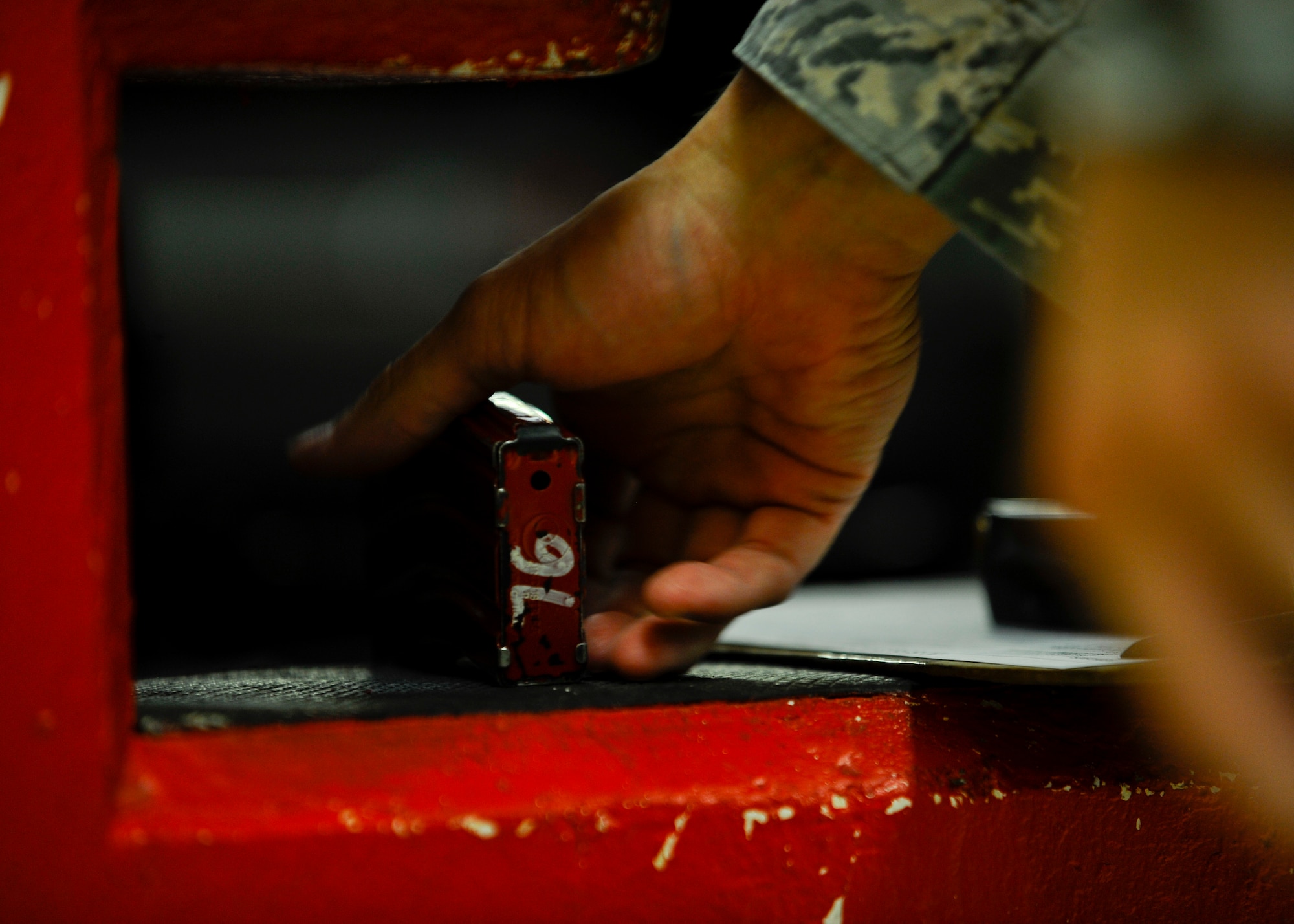 An Airman from the 22nd Security Forces Squadron picks up an ammunition magazine from the 22nd SFS armory, Aug. 4, 2015, at McConnell Air Force Base, Kan. All Defenders are issued gear through the armory, including their firearms, stun guns, batons and radios before their shift begins. (U.S. Air Force photo by Senior Airman Victor J. Caputo)