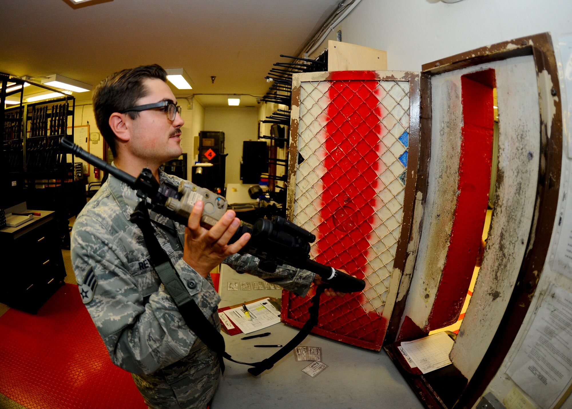 Senior Airman Cody Reynolds, 22nd Security Forces Squadron on-duty armorer, hands off an M4 carbine, Aug. 4, 2015, at McConnell Air Force Base, Kan. Patrolmen are issued their weapons, radios and other equipment from the armory at the beginning of each shift providing them a centralized location to pick up their required gear. (U.S. Air Force photo by Senior Airman Victor J. Caputo)