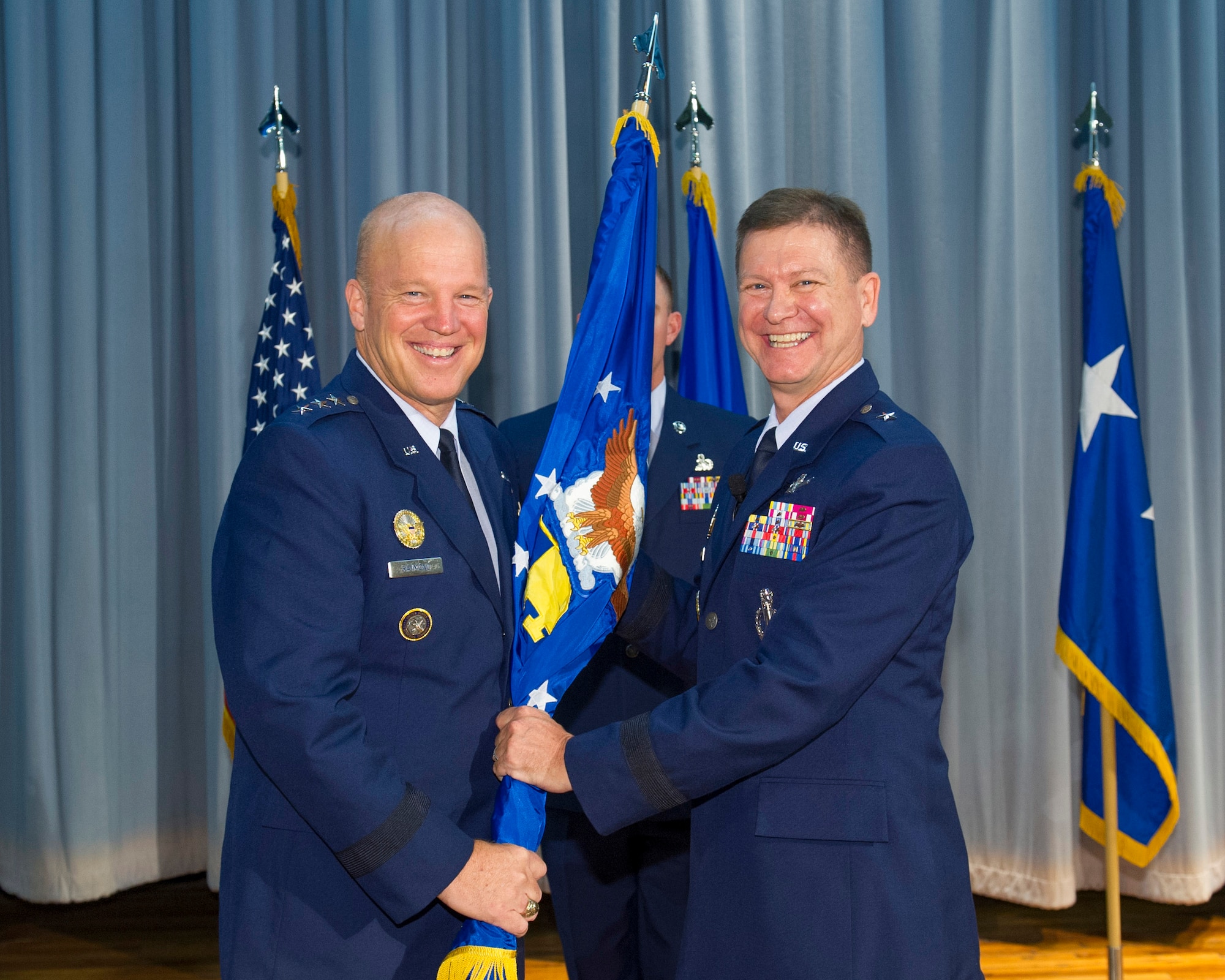 Lt. Gen. John W. "Jay" Raymond, commander, 14th Air Force (Air Forces Strategic) and Joint Functional Component Command for Space, presents Brig. Gen. Wayne Monteith, 45th Space Wing commander during a change of command ceremony, Aug. 4, 2015, at Patrick Air Force Base, Florida. Changes of command are a military tradition representing the transfer of responsibilities from the presiding officials to the upcoming official. (U.S. Air Force photo/Matthew Jurgens) (Released) 