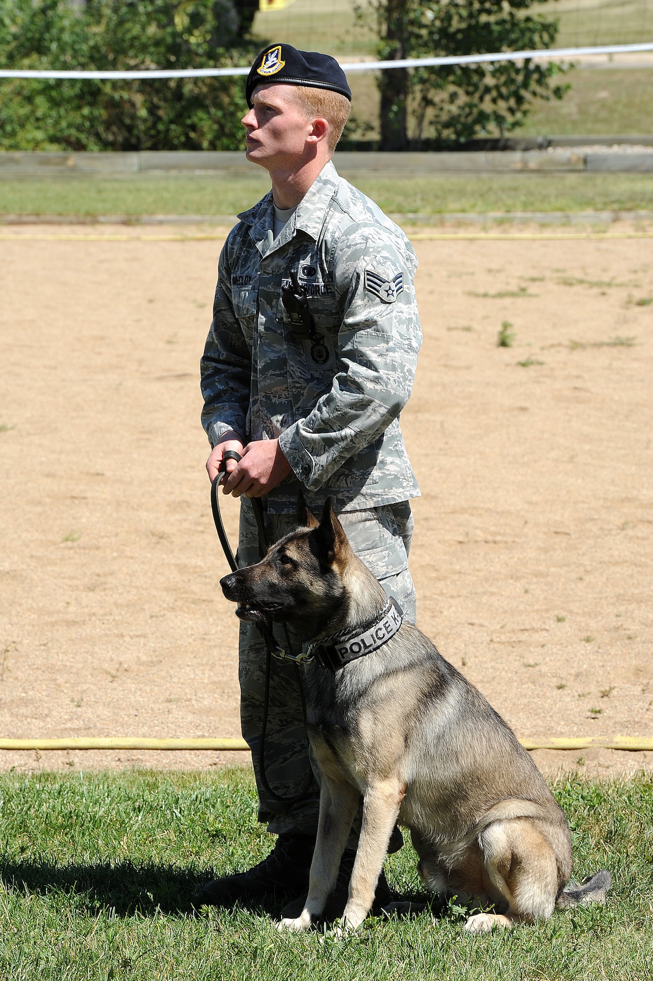 Senior Airman Andrew McCloy, 5th Security Forces Squadron K-9 handler, stands with his dog during a SF demonstration during the “Hero in Training” event at Minot Air Force Base, N.D., July 31, 2015. The event showcased displays from the fire department, security forces squadron, medical group and other base agencies. (U.S. Air Force photo/Senior Airman Kristoffer Kaubisch)