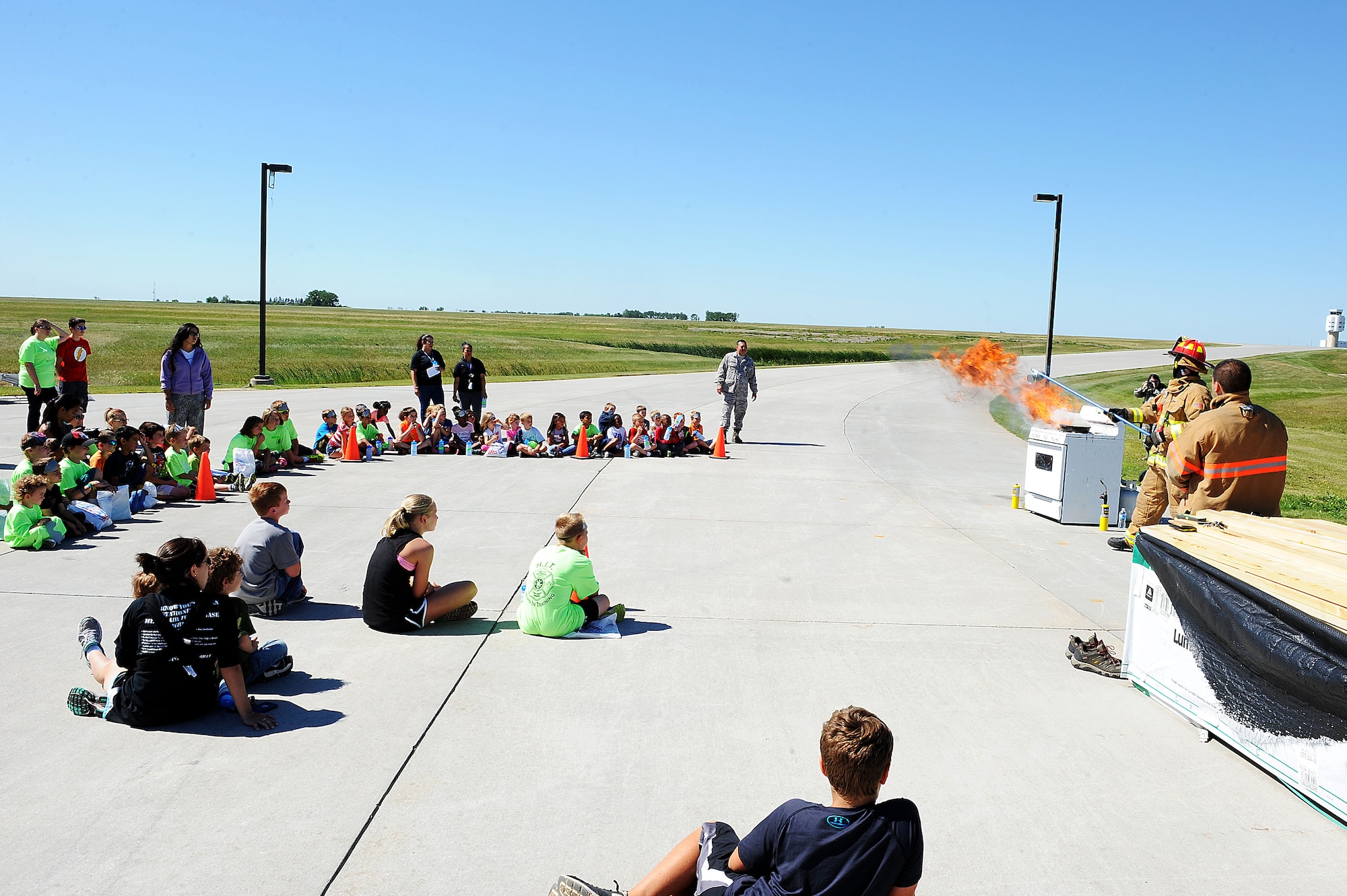 Staff Sgt. Sean Cantrell, 5th Civil Engineer Squadron fire station captain, demonstrates the effects of putting water on a grease fire during the “Hero in Training” event at Minot Air Force Base, N.D., July 31, 2015. The fire department hosted the day-long event which featured displays from their group, the 5th Security Forces Squadron, 5th Medical group and a variety of other base agencies. (U.S. Air Force photo/Senior Airman Kristoffer Kaubisch)