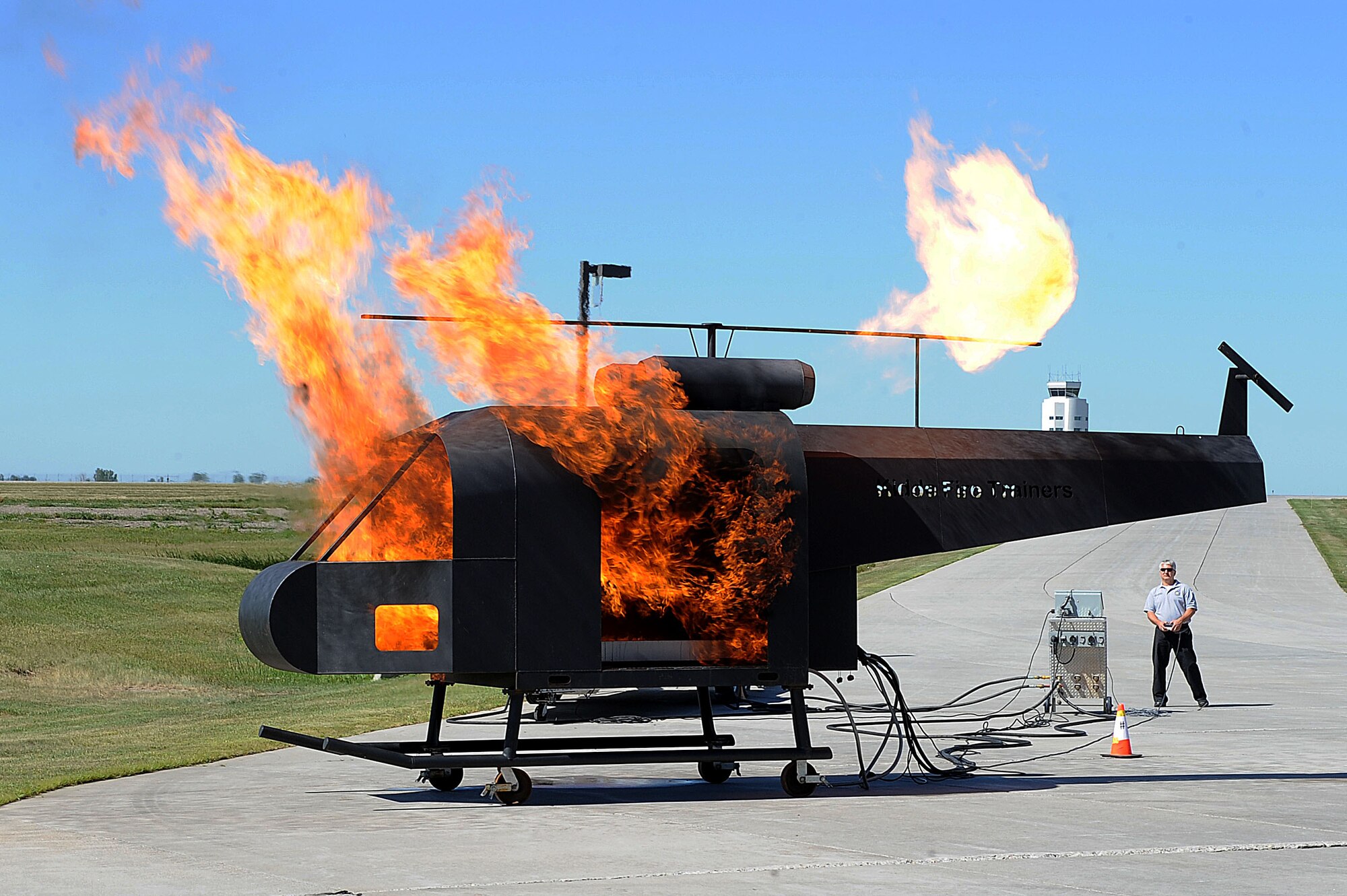 A training helicopter is set on fire to showcase the capabilities of the base fire department during the “Hero in Training” event at Minot Air Force Base, N.D., July 31, 2015. The fire department hosted the day-long event which featured displays from their group, the 5th Security Forces Squadron, 5th Medical group and a variety of other base agencies. (U.S. Air Force photo/Senior Airman Kristoffer Kaubisch)