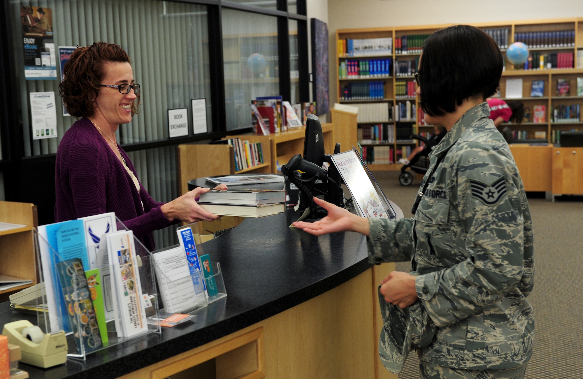 Air Force Staff Sgt. Krystal Malveaux, 509th Aircraft Maintenance Squadron weapons specialist, returns books to Anne Neudorf, 509th Force Support Squadron library aid, July 28, 2015, at Whiteman Air Force Base, Mo. For patrons ages 10 and older, library cards are freely available and can be used to check out items, as well as access the vast entirety of online resources. (U.S. Air Force photo by Airman 1st Class Jazmin Smith/Released)