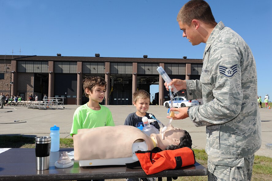 Staff Sgt. Jacob Alsteen, 5th Medical Group aerospace medical technician, demonstrates the procedures of ambulance services to base children during the “Hero in Training” event at Minot Air Force Base, N.D., July 31, 2015. The event showcased displays from the fire department, security forces squadron, medical group and other base agencies. (U.S. Air Force photo/Senior Airman Kristoffer Kaubisch)