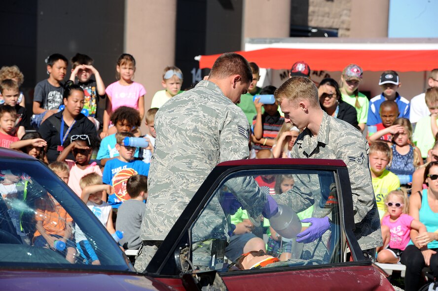 Airmen from the 5th Medical Group and base fire department remove a dummy from a simulated car accident during the “Hero in Training” event at Minot Air Force Base, N.D., July 31, 2015. During the demonstration, fire fighters showed base children and their families tools, such as the jaws of life, and procedures they use to rescue car crash victims. (U.S. Air Force photo/Senior Airman Kristoffer Kaubisch)