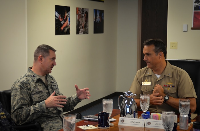 Colonel Robert Lyman, Joint Base Charleston commander, conducts an office call with Navy Captain Maxwell Shuman, the commanding officer of Navy Munitions Command, Continental United States East Division, based in Yorktown, Va. The Navy Munitions Command is designed to align all ashore ordnance support operations in the United States and Asia into one worldwide unit and consolidate 2,100 personnel under three divisions: CONUS East Division, CONUS West Division and East Asia Division. (U.S. Air Force photo/Staff Sgt. AJ Hyatt)