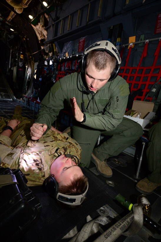 U.S. Wyoming Air National Guardsman, Senior Airman Shawn Smith, Aeromedical Evacuation technician with the 187th Aeromedical Evacuation Squadron, Cheyenne Wyo., checks a simulated patient’s pupil activity onboard an MC-130P Combat Shadow aircraft during Angel Thunder 2015 exercises at Davis-Monthan AFB, Ariz., June 7, 2015.  The way in which pupils react to light can indicate if the patient has sustained head trauma. (U.S. Air National Guard photo by Senior Airman Rachael Kane/Released)