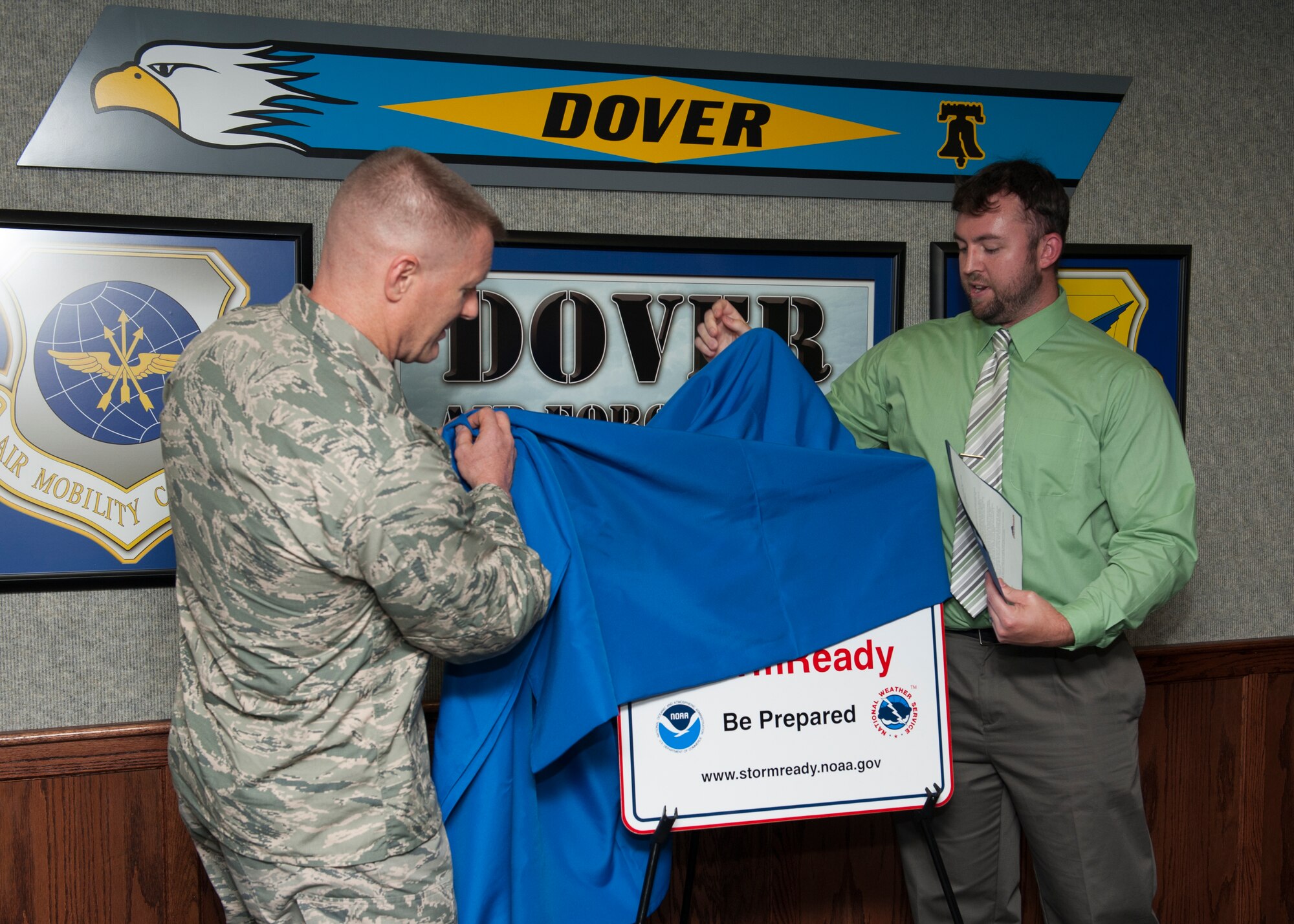 Col. Michael Grismer, 436th Airlift Wing commander, and Greg Heavener, National Oceanic and Atmospheric Administration meteorologist, unveil Dover Air Force Base’s new StormReady sign July 29, 2015, at Dover AFB, Del. Heavener, presented the base with this sign to officially designate it with a StormReady certification. (U.S. Air Force photo/Airman 1st Class Zachary Cacicia)