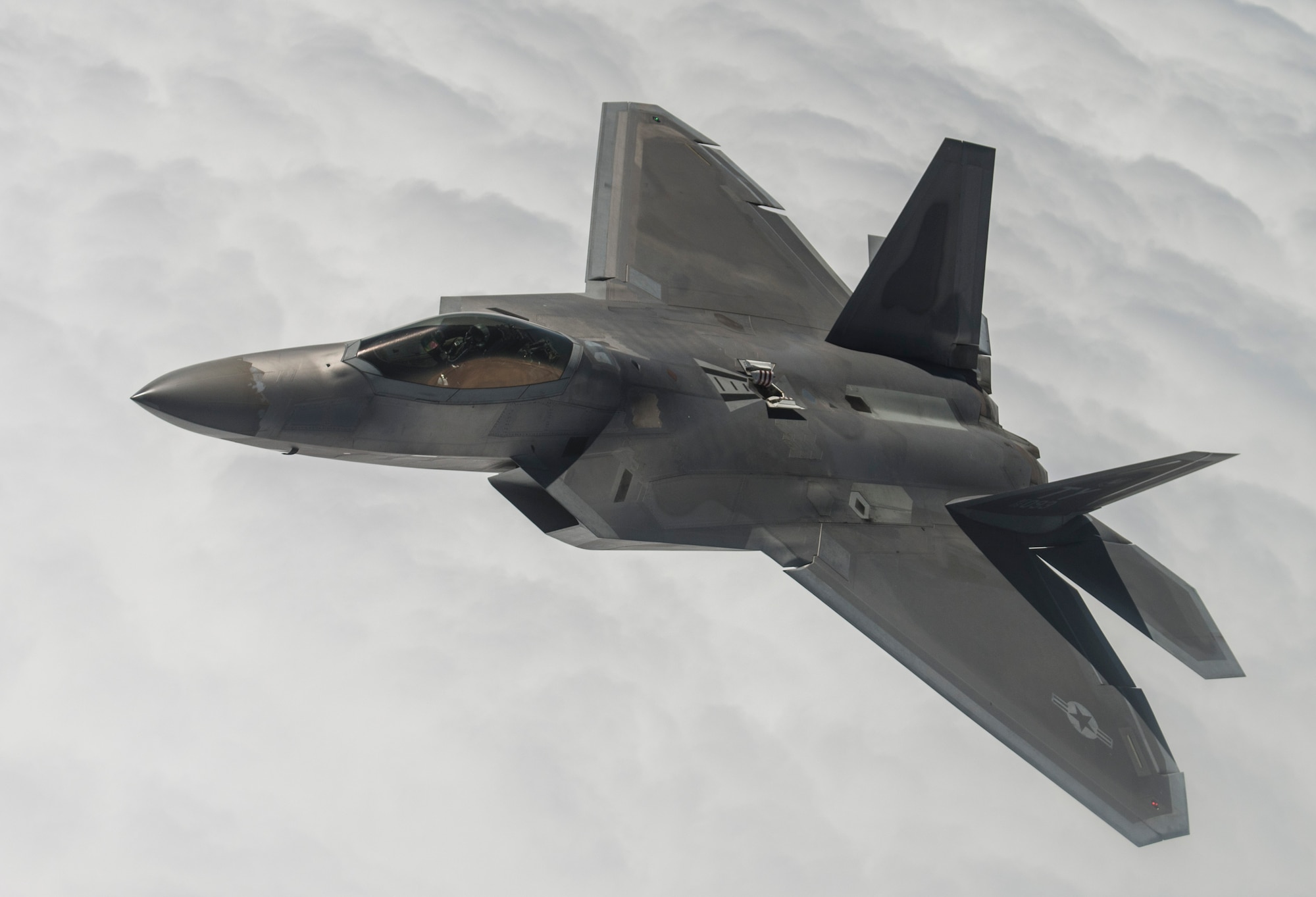 An F-22A Raptor from the 95th Fighter Squadron stationed with the 325th Fighter Wing, Tyndall Air Force Base, Florida, flies beside a KC-135 Stratotanker from the 93rd Air Refueling Squadron, Fairchild AFB, Washington, while waiting for others to receive fuel over the Nevada Test and Training Range during Red Flag 15-3 at Nellis AFB, Nevada, July 31, 2015. Red Flag gives aircrews and air support operations service members from various airframes, military services, and allied countries an opportunity to integrate and practice combat operations. (U.S. Air Force photo by Senior Airman Brittany A. Chase)
