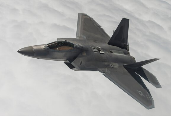 An F-22A Raptor from the 95th Fighter Squadron stationed with the 325th Fighter Wing, Tyndall Air Force Base, Florida, flies beside a KC-135 Stratotanker from the 93rd Air Refueling Squadron, Fairchild AFB, Washington, while waiting for others to receive fuel over the Nevada Test and Training Range during Red Flag 15-3 at Nellis AFB, Nevada, July 31, 2015. Red Flag gives aircrews and air support operations service members from various airframes, military services, and allied countries an opportunity to integrate and practice combat operations. (U.S. Air Force photo by Senior Airman Brittany A. Chase)