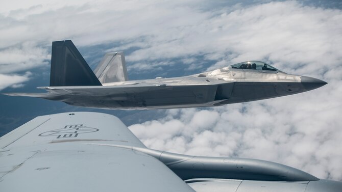 An F-22A Raptor from the 95th Fighter Squadron stationed with the 325th Fighter Wing, Tyndall Air Force Base, Florida, flies beside a KC-135 Stratotanker from the 93rd Air Refueling Squadron Fairchild Air Force Base, Wash., over the Nevada Test and Training Range during Red Flag 15-3 at Nellis AFB, Nevada, July 31, 2015. After receiving fuel the aircrews wait for their wingmen before continuing on with their specific mission. The exercise is conducted above the 2.9 million square acre NTTR north of Las Vegas. (U.S. Air Force photo by Senior Airman Brittany A. Chase)