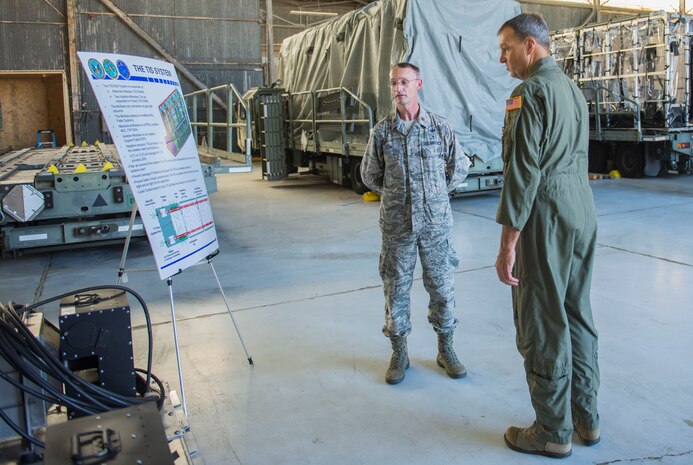 Major Richard Yon, 628th Aerospace Medical Squadron Bio Engineering flight commander, explains the details of the Transport Isolation System to Brig. Gen. Kory Cornam, the Air Mobility Command surgeon general, on July 30, 2015, in building 575 on the flight line at Joint Base Charleston, S.C. Major Yon was coined for his dedication and hard work to the project. (U.S. Air Force photo/ Thomas T. Charlton)