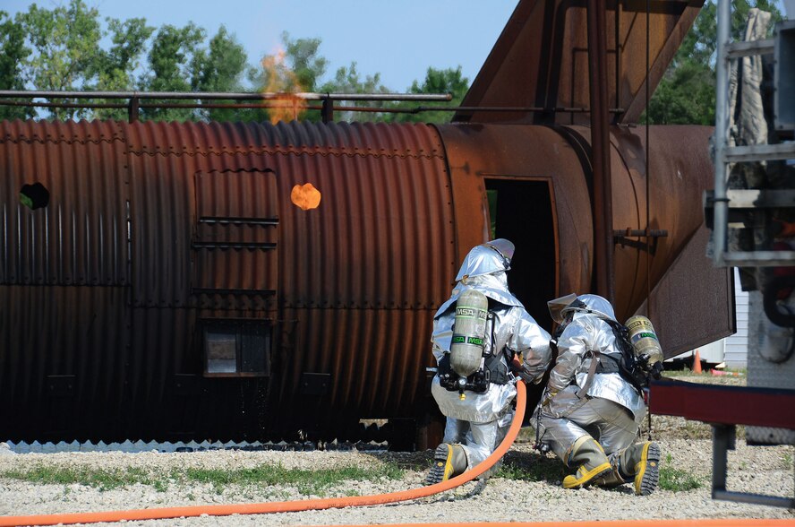 WRIGHT-PATTERSON AIR FORCE BASE, Ohio – Fire and Emergency personnel from the 445th Civil Engineer Squadron extinguish a mock aircraft fire during a training exercise July 11, 2015. The annual training allows firefighters to practice incident-command and emergency scenarios in a controlled learning environment. (U.S. Air Force photo/Senior Airman Joel McCullough)