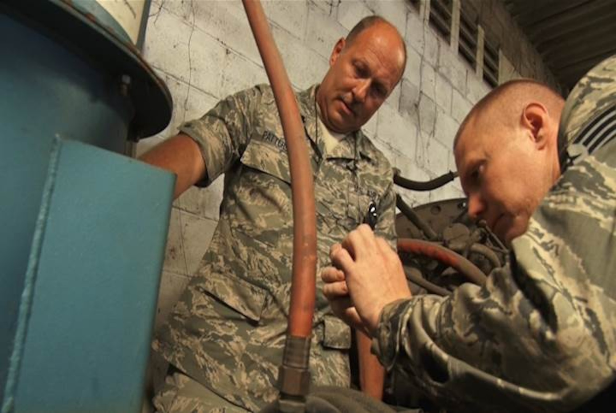 Tech. Sgt. Glen Patterson, 157th Aircraft Maintenance Squadron aircraft structural maintenance technician, and Staff Sgt. Andrew Morrison, 157 AMS aircraft structural maintenance craftsman, take a closer look at a Plastic Reclaimable Abrasive Machine (PRAM) that has been inoperable for over ten years. This item was a gift to the Salvadorian Air Force, and they hope that through their partnership with the New Hampshire Air National Guard, they can assist with restoring this piece of equipment for future use. Airmen from the 157 AMS spent a week in El Salvador, July 21 through 24, 2015, as part of the on-going New Hampshire state partnership program with El Salvador. (U.S. Air National Guard photo by Tech. Sgt. Erica Rowe) 