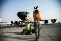 A U.S. Air Force Airman marshals an RC-135V/W Rivet Joint aircraft into position July 24, 2015, at Al Udeid Air Base, Qatar. The Rivet Joint aircraft has maintained a constant presence in Southwest Asia since the early 1990s. The aircraft and crew are deployed from Offutt Air Force Base, Neb. in support of Operation Inherent Resolve and Operation Freedom’s Sentinel. (U.S. Air Force photo by Tech. Sgt. Rasheen Douglas)