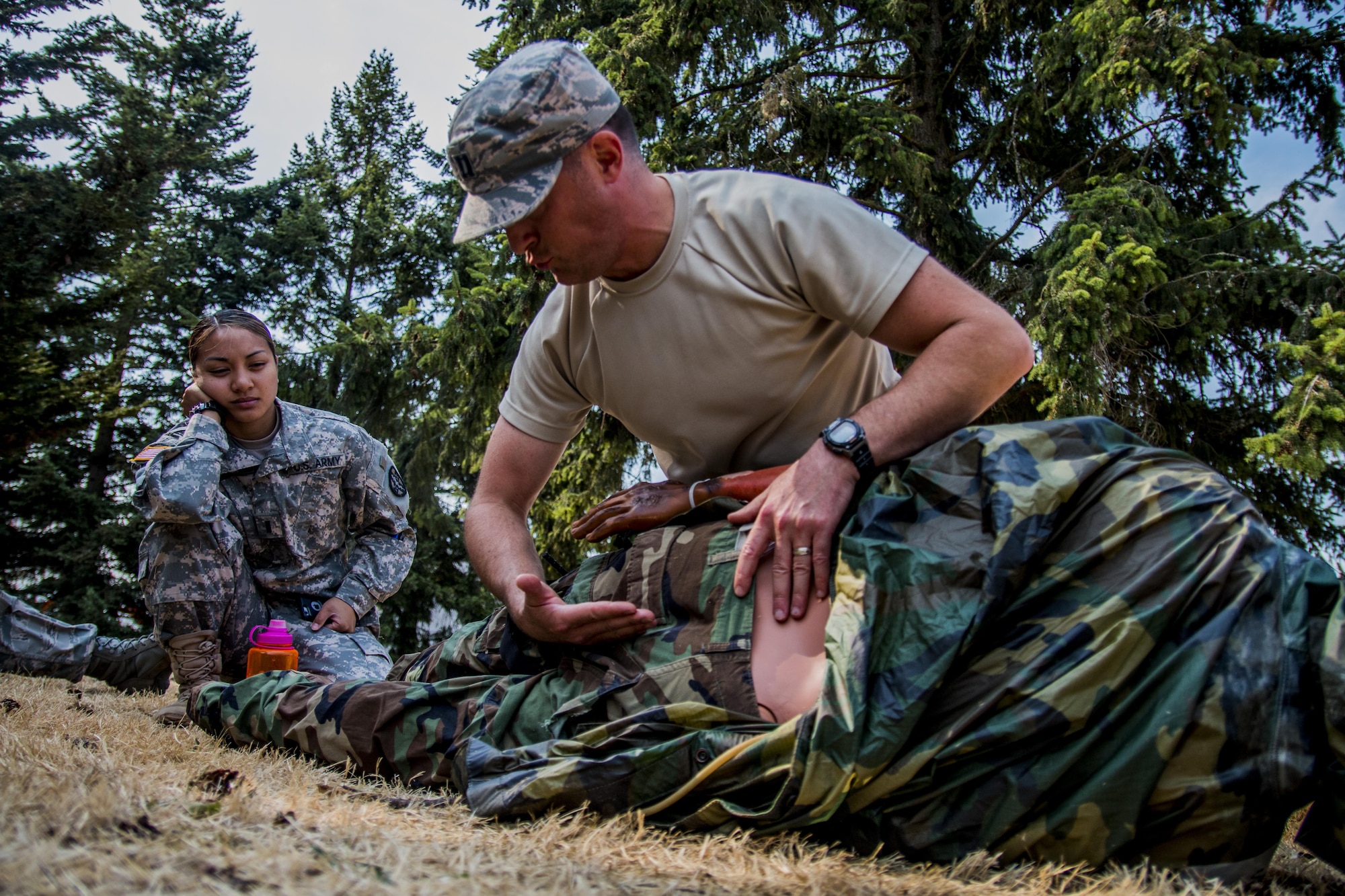 Captain Ryan Garabrandt, 446th Aeromedical Staging Squadron nurse, checks for spinal injuries on a training manikin in preparation for the annual Expert Field Medical Badge test at McChord Field, Wash., Aug. 2, 2015. The Expert Field Medical Badge is a unique distinction worn only by the most battle-ready and elite medical personnel in the military. Every year at Joint Base Lewis-McChord, Wash., a  two-week intensive testing event is set up to qualify eligible service members from around the country for the right to wear the coveted badge. (U.S. Air Force photo by Senior Airman Daniel Liddicoet)