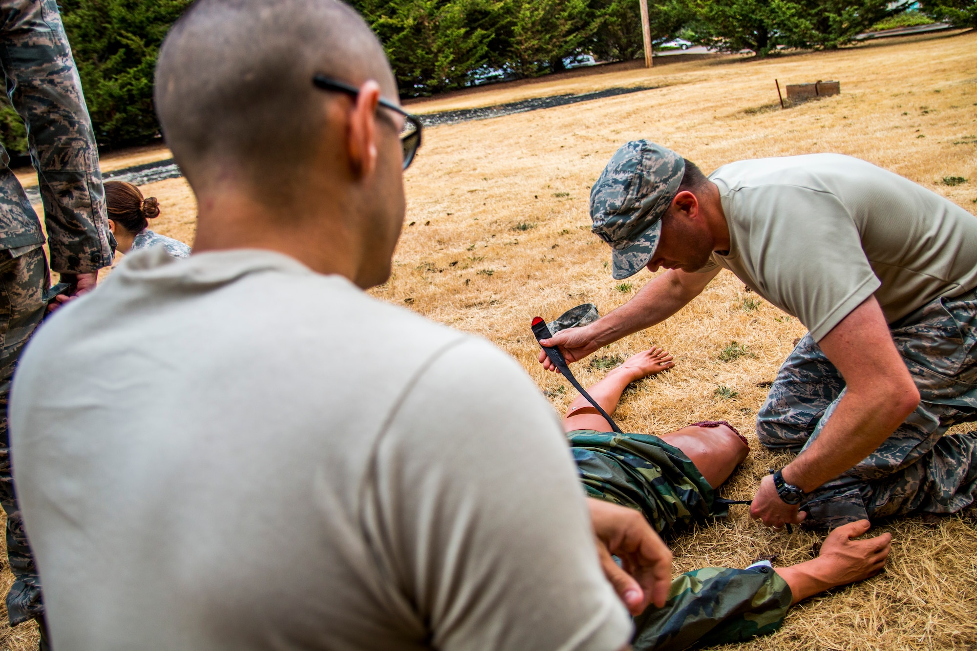 Captain Ryan Garabrandt, 446th Aeromedical Staging Squadron nurse, applies a tourniquet to a training manikin in preparation for the annual Expert Field Medical Badge test at McChord Field, Wash., Aug. 2, 2015. The Expert Field Medical Badge is a unique distinction worn only by the most battle-ready and elite medical personnel in the military. Every year at Joint Base Lewis-McChord, Wash., a  two-week intensive testing event is set up to qualify eligible service members from around the country for the right to wear the coveted badge. (U.S. Air Force photo by Senior Airman Daniel Liddicoet)