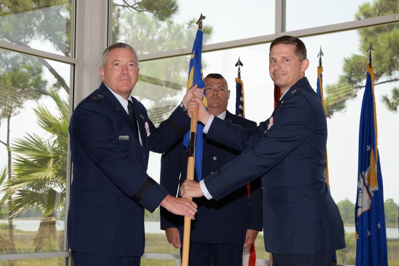 During the Air Force Rescue Coordination Center change of command ceremony, Lt. Gen. William Etter, Commander, Continental U.S. Aerospace Defense Command Region – 1st Air Force ( Air Forces Northern) accepts the command guidon as Lt. Col. Ian Kemp, relinquishes command. (U.S. Air Force photo released/Capt. Jared Scott)