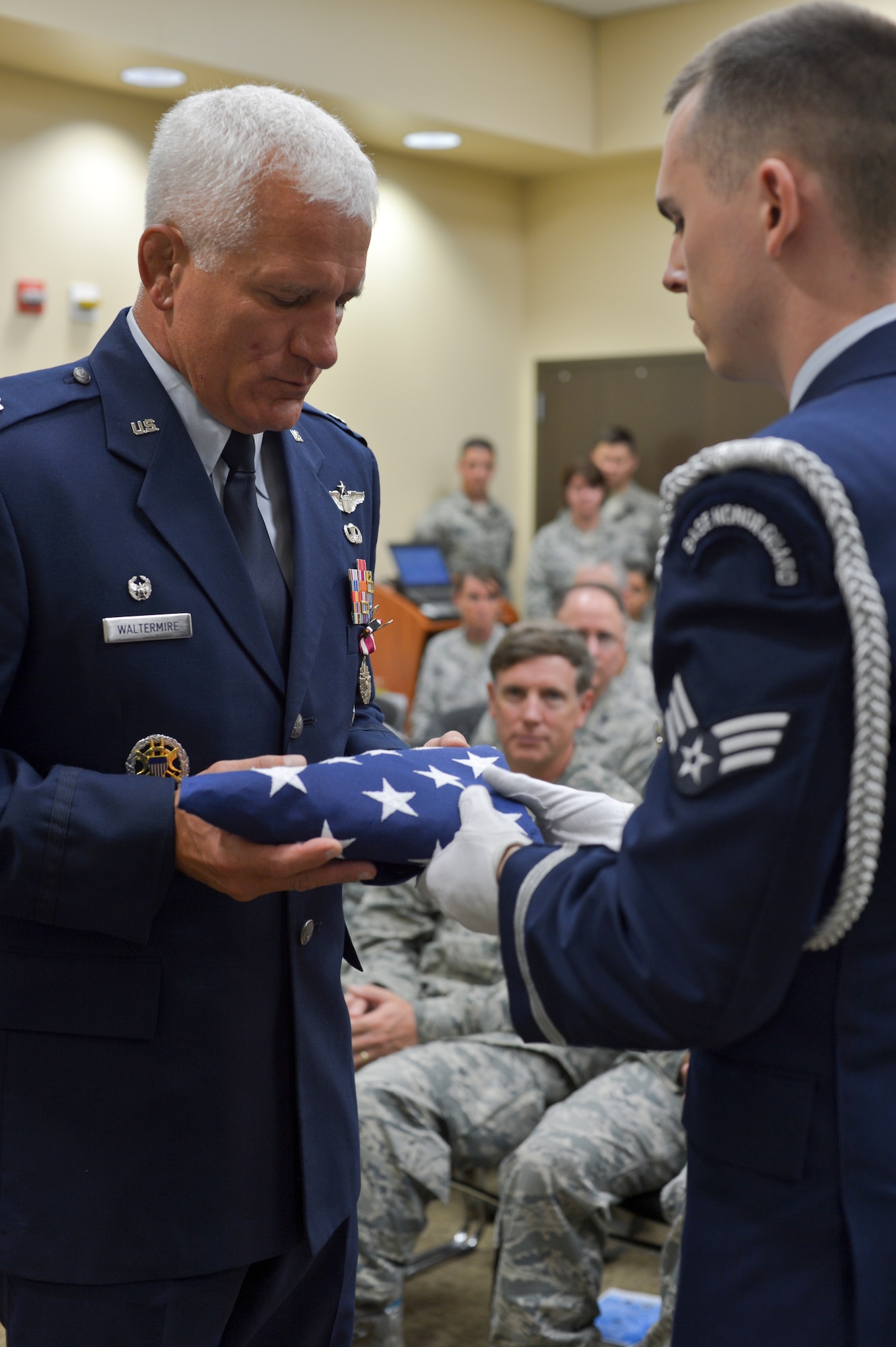 Air Force Lt. Col. James B. Waltermire receives the U.S. flag during his retirement ceremony, August 2, 2015, at the 146th Air Support Operations Squadron, Will Rogers Air National Guard Base. The 146 ASOS held a joint ceremony honoring Lt. Col. Waltermire and welcoming Air Force Maj. Christopher D. Gries as the new squardron commander. (U.S. Air National Guard photo by Tech. Sgt. Caroline Essex/Released) 