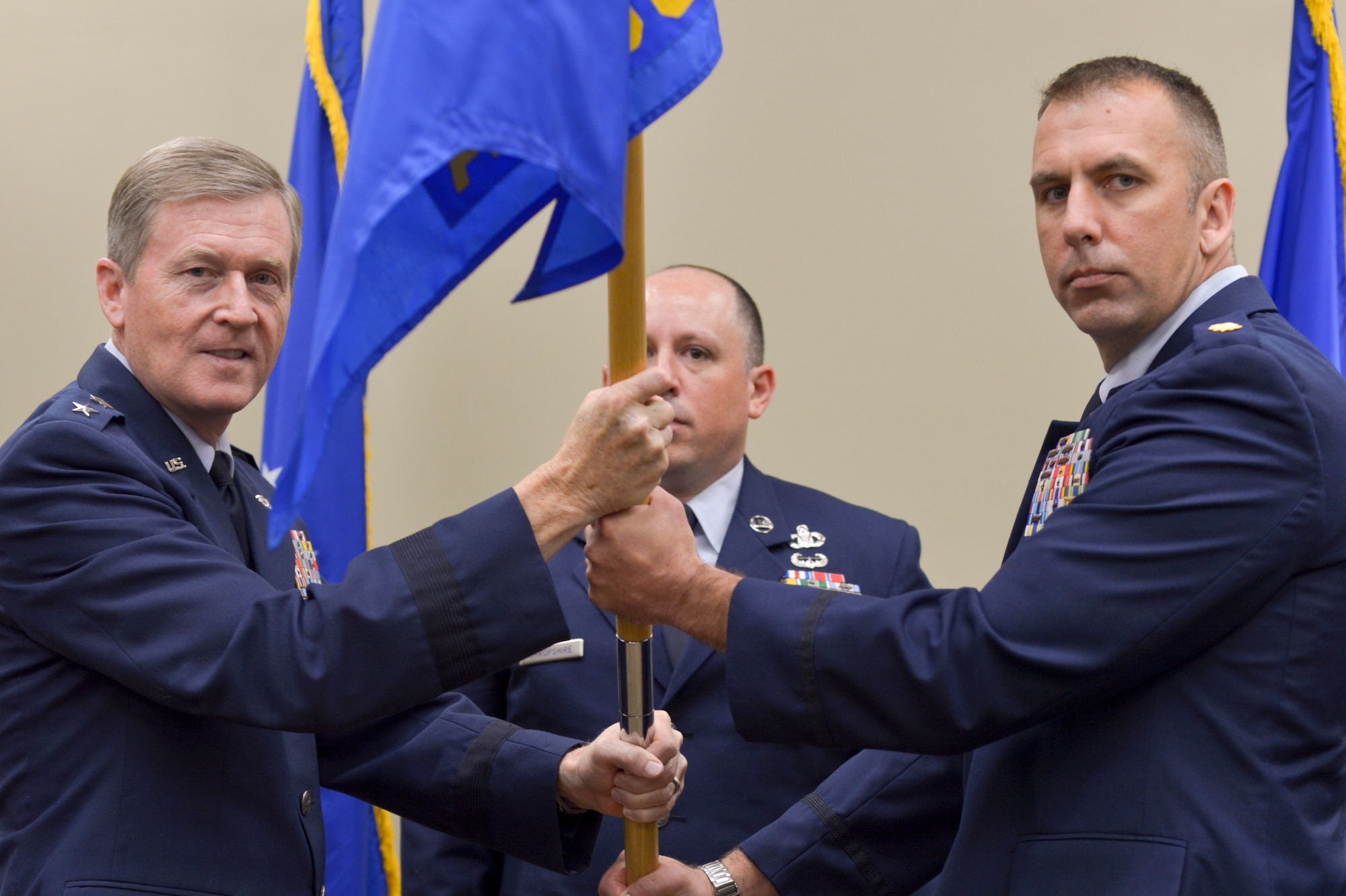 Air Force Maj. Christopher D. Gries accepts command of the 146th Air Support Operations Squadron from Air Force Maj. Gen. Gregory L. Ferguson, AFSOC mobilization assistant to the commander, August 2, 2015, Will Rogers Air National Guard Base. The 146 ASOS held a joint ceremony honoring Lt. Col. Waltermire and welcoming Air Force Maj. Christopher D. Gries as the new squardron commander. (U.S. Air National Guard photo by Tech. Sgt. Caroline Essex/Released)