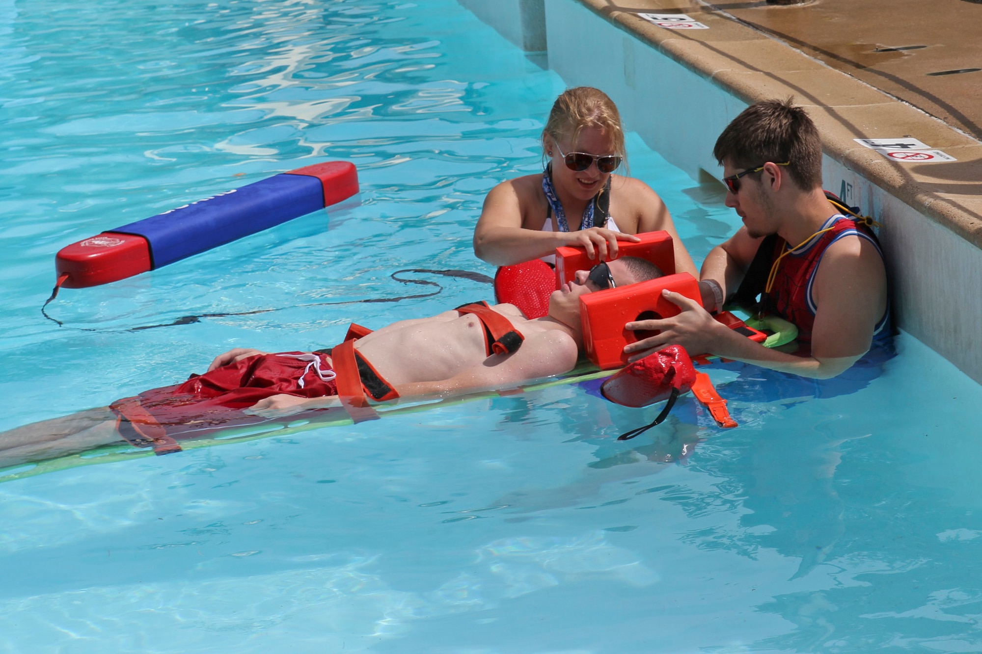 DENVER – Lifeguards from the Peterson Air Force Base Aquatic Center compete in the back boarding scenario portion of the 30th Annual Colorado Parks and Recreation Association Lifeguard Games at Water World, July 12, 2015. The team competed in the games to test their life-saving skills against other area lifeguards, placing in three out of six events. (Courtesy photo by Stephen Steinke)