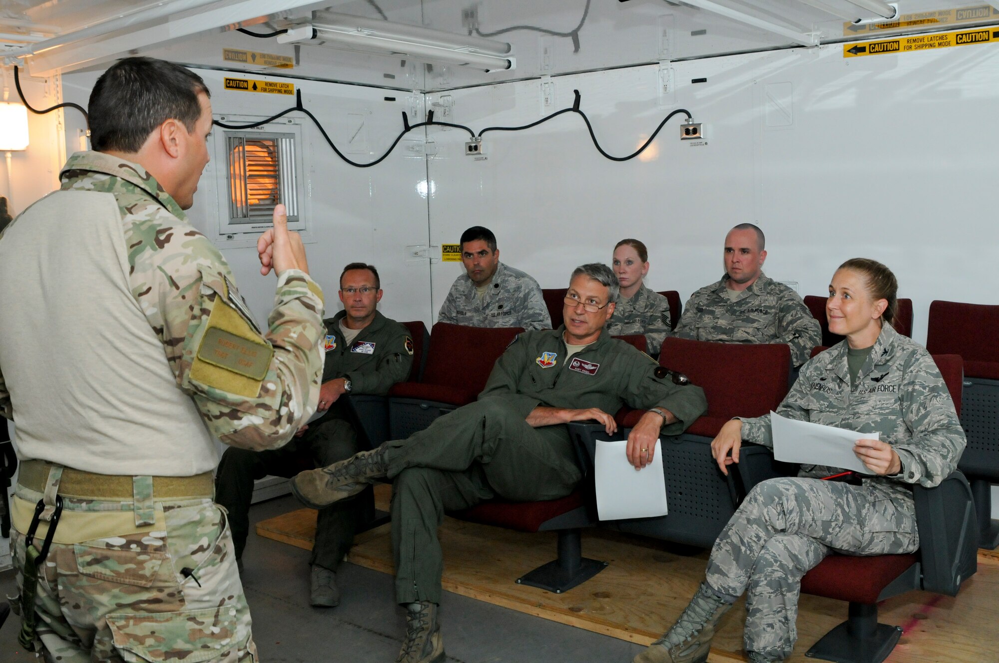 Tech. Sgt. Robert Ellis, Detachment 1 Joint Terminal Attack Controller liaison and evaluator, briefs members of the Arkansas Joint Force Headquarters on the upcoming training mission at Razorback Range Det. 1 located at Fort Chaffee Maneuver Training Center, Ark. Aug. 1, 2015. Razorback Range is a key asset that provides unique, quality training opportunities for all branches of the military, special operations forces and aviation units on close air support, combat search and rescue and also provides specialized training for units. (U.S. Air National Guard photo by Capt. Holli Nelson/Released)