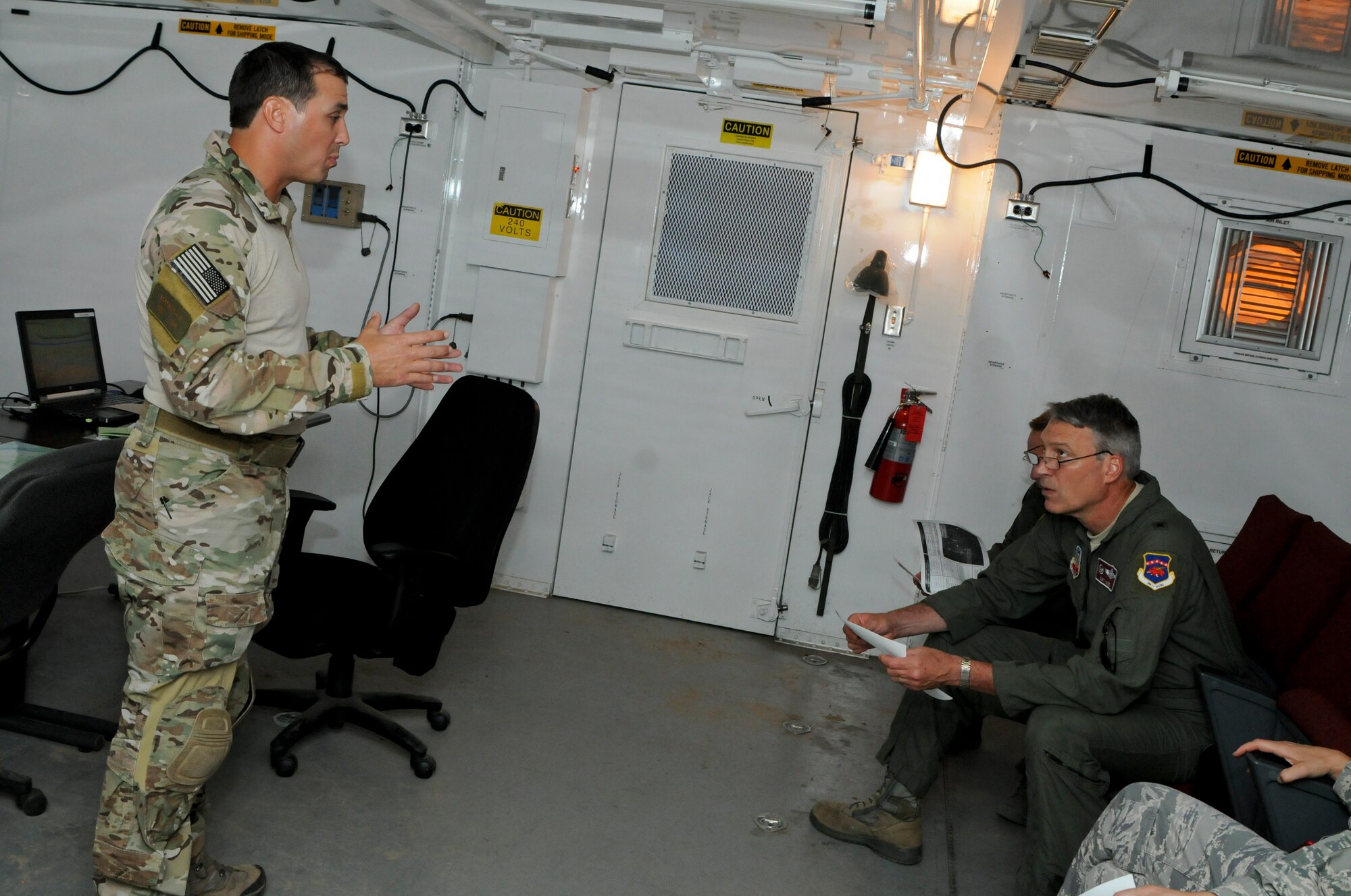 Tech. Sgt. Robert Ellis, Detachment 1 Joint Terminal Attack Controller liaison and evaluator, briefs members of the Arkansas Joint Force Headquarters on the upcoming training mission at Razorback Range Det. 1 located at Fort Chaffee Maneuver Training Center, Ark. Aug. 1, 2015. Razorback Range is a key asset that provides unique, quality training opportunities for all branches of the military, special operations forces and aviation units on close air support, combat search and rescue and also provides specialized training for units. (U.S. Air National Guard photo by Capt. Holli Nelson/Released)