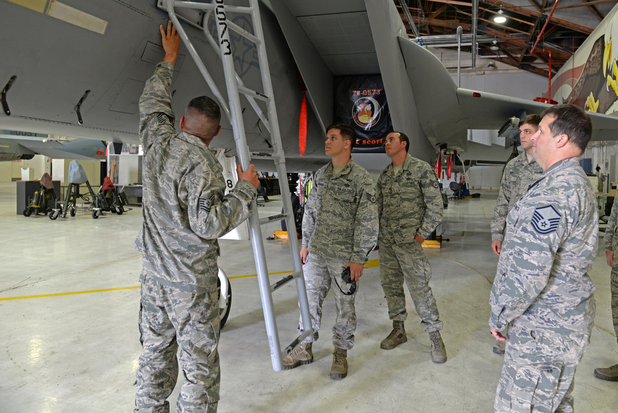Tech. Sgt. Brent Hublitz (left), 173rd Fighter Wing egress ordnance technician, trains members from 9th Civil Engineer Squadron Explosive Ordinance Disposal Flight, egress protocol on an F-15 Eagle at Kingsley Field Air National Guard Base, Oregon, July 30, 2015. The EOD technicians received hands on training and provided safety support for Sentry Eagle 15 July 30 to Aug. 2, 2015. (U.S. Air Force photo by Airman 1st Class Ramon A. Adelan)