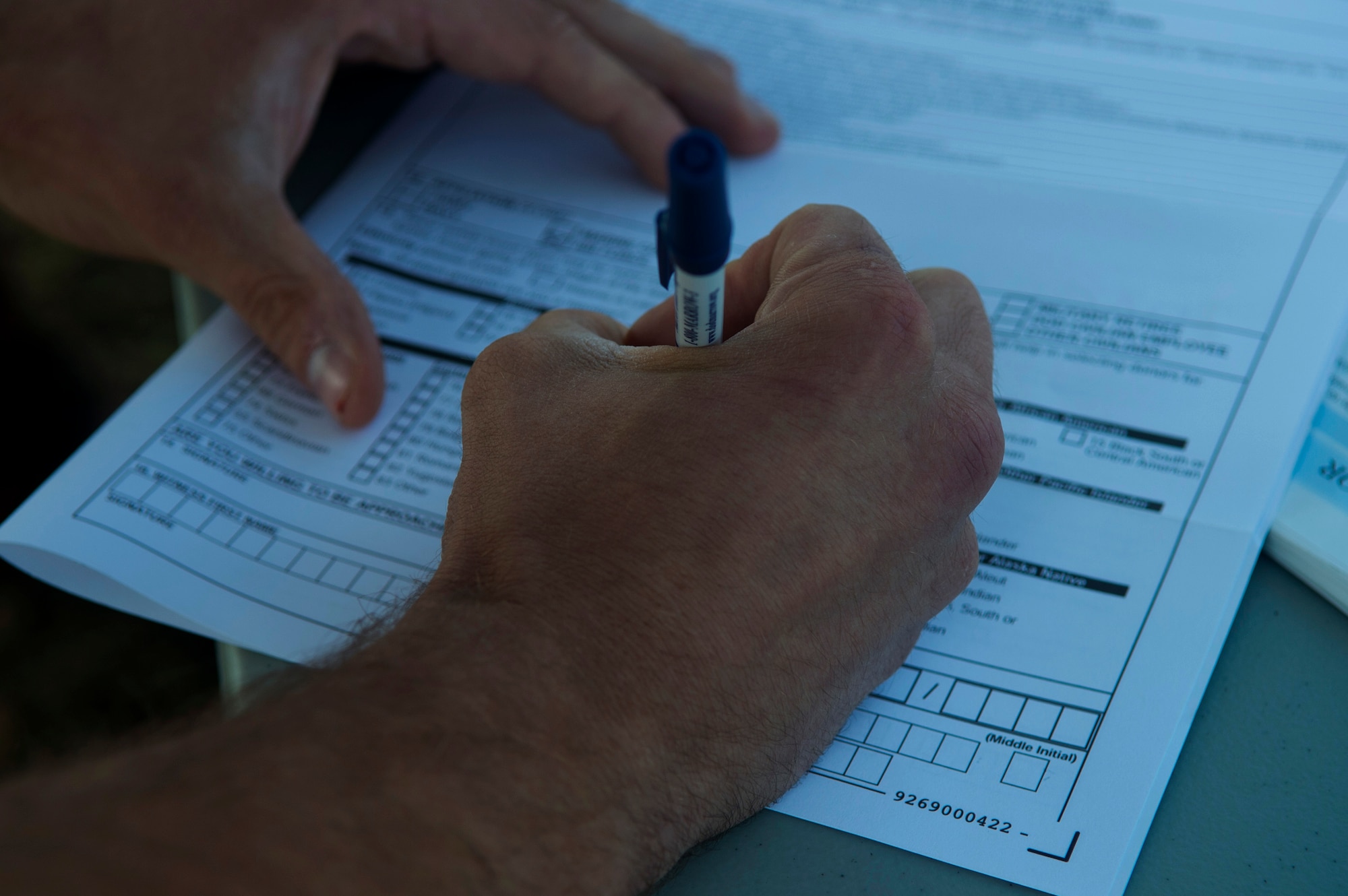 An Airman fills out a C.W. Bill Young Department of Defense Marrow Donor registration form during the Relay for Life event at the outdoor track on Spangdhalem Air Base, Germany, July 31, 2015. Qualifications to register as a marrow donor include being between the ages of 18 and 60, in general good health, and a DoD identification card holder. (U.S. Air Force photo by Airman 1st Class Luke Kitterman/Released) 