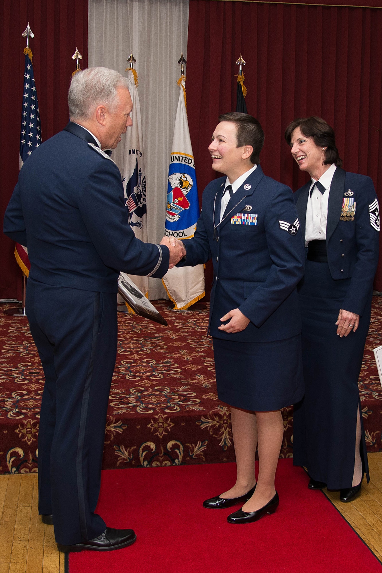 Air Force Life Cycle Management Center Commander Lt. Gen. John Thompson congratulates Senior Airman Alyssa R. Arriaga, 58th Aerial Port Squadron, Westover Air Reserve Base, Mass., on being named the John L. Levitow Award winner during the Airman Leadership School graduation ceremony at the Minuteman Commons July 31, as AFLCMC Command Chief Master Sgt. Doreen Losacco looks on. Arriaga and 11 others completed the five-week Professional Military Education class designed to develop junior enlisted members into effective front-line supervisors. (U.S. Air Force photo by Mark Herlihy)